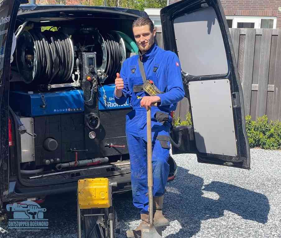 Een monteur bij de werkbus met grote hogedruk-slanghaspels, apparatuur voor hardnekkige afvoerverstoppingen in Roermond