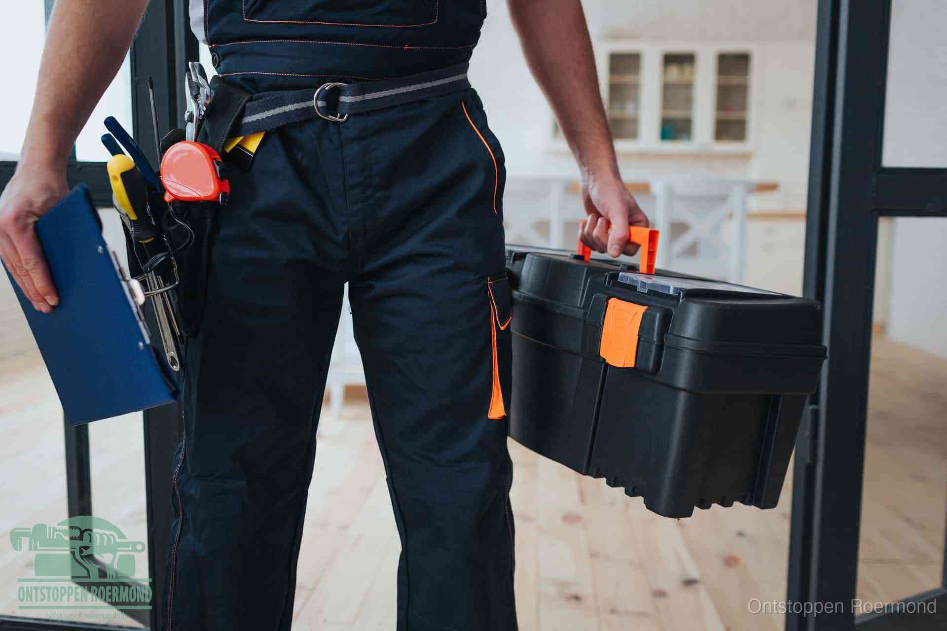 Een monteur met gereedschapsriem en klembord, klaar om een transparante prijs voor het afvoer ontstoppen in Roermond te geven