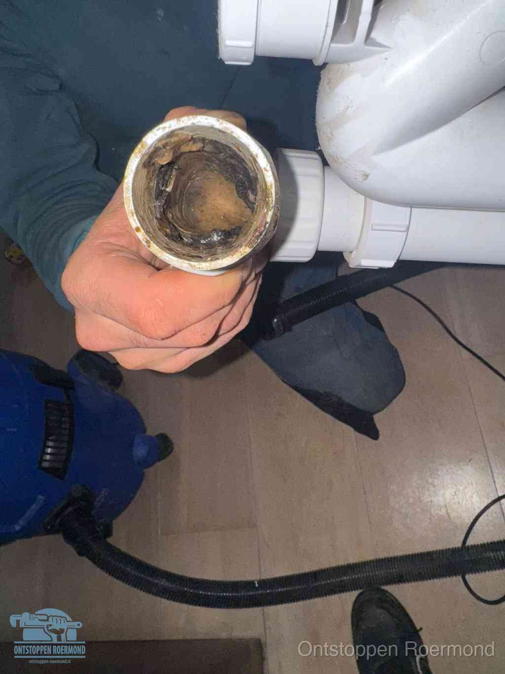 Een losgekoppelde afvoerbuis die van binnen volledig is dichtgeslibd met vet en aanslag, de meest voorkomende oorzaak van een verstopte gootsteen in Roermond