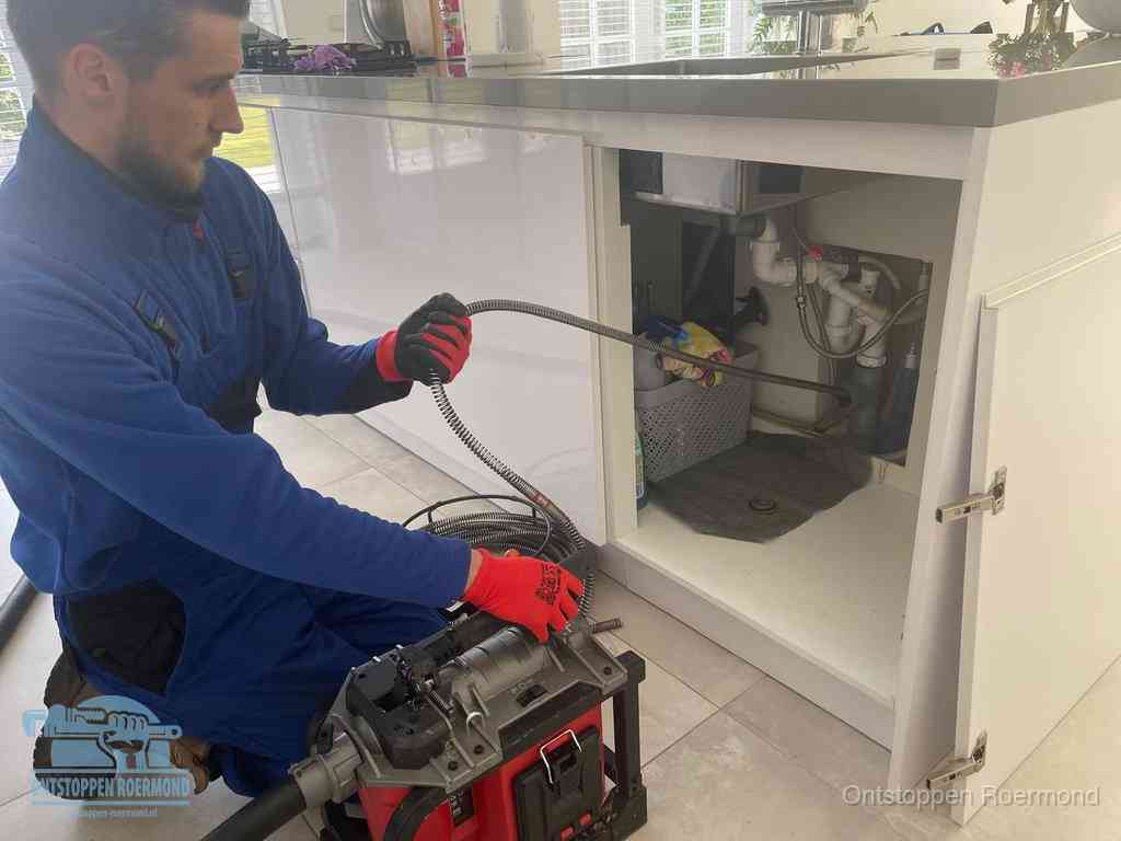 Een monteur reinigt de keukenafvoer grondig met een veermachine om terugkerende gootsteenverstoppingen te voorkomen in Roermond
